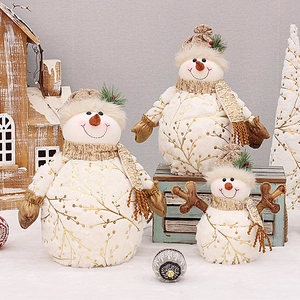 Three plush snowman figurines with gold branch prints and knit hats for Christmas decor