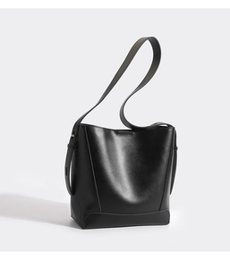 Detailed close-up of a black leather bucket bag with an adjustable shoulder strap and texture