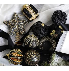 Close-up of black and gold Christmas ornaments including foam balls and tree top star