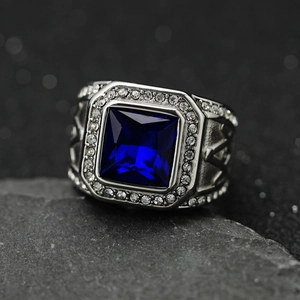 Macro shot of men's ring with large blue sapphire stone and small white diamonds