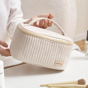 Quilted cream PU leather makeup bag with LOVE PEACE tag and sturdy carry handle