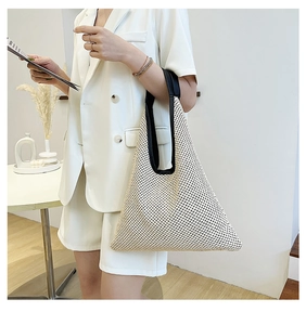 Detail of woven beige handbag with triangle silhouette and black leather handle