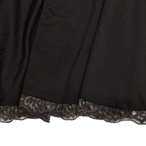 Close-up of black fabric with intricate brown lace embroidery on the bottom edge