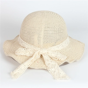 Vue détaillée du tressage de paille beige et du nœud en dentelle sur le chapeau