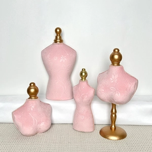 Detail of pink embossed velvet bust stands for jewelry display with gold top beads