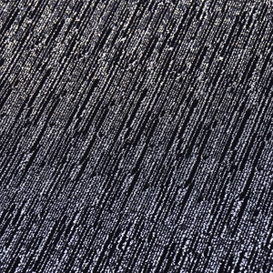 Vue macro d'un tissu noir tricoté avec des fils argentés scintillants et texture détaillée