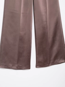 Detailed view of chocolate satin wide-leg trousers featuring a smooth glossy finish
