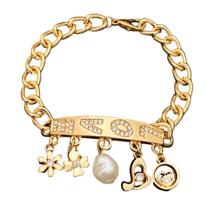 Gold chain bracelet featuring MOM letter plaque with flower, heart, and pearl charms
