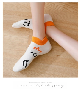Detail of white cotton low-cut socks with cartoon goose face and orange ribbed cuffs