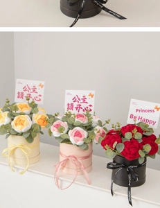 Detailed view of hand-knitted flower bouquets in cylindrical boxes with elegant ribbons