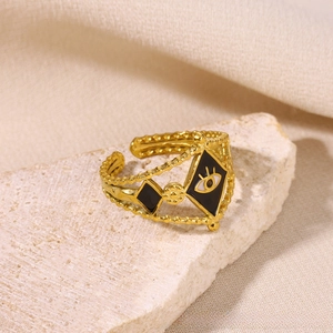 Macro view of gold evil eye ring with black enamel inlay and beaded texture detail