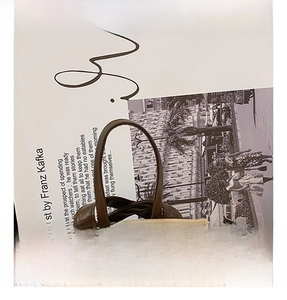Detail view of the vintage brown leather bag with a twisted rope handle and grainy texture
