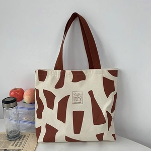 Detail of beige canvas tote bag with red geometric pattern and Good Student rabbit print