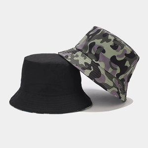 Detail showing two reversible bucket hats in solid black and green camouflage pattern