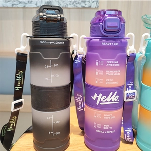 Close-up of 1000ml sports water bottle with gradient color, time scale and carry strap