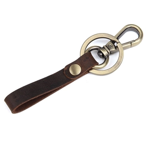Detail of vintage genuine leather keychain with bronze metal hook and spring clasp