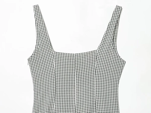 Gros plan sur l'encolure carrée et la texture d'une robe midi vichy noire et blanche
