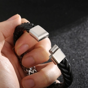 Detail showing the magnetic clasp on a double-row braided black leather bracelet