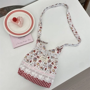 Detail of cartoon floral crossbody bag with white lace trim and red plaid pattern