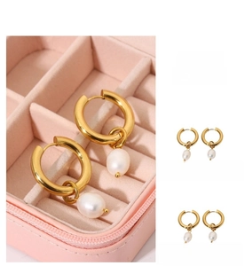 Close-up of gold plated round hoop earrings featuring elegant white teardrop pearl pendants