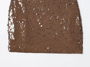 Gros plan sur le tissu pailleté marron montrant la texture et le fini brillant