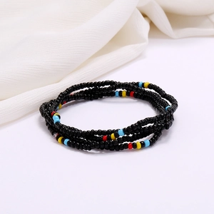 Detailed close-up of multi-layer handmade colorful glass seed bead waist chains on white fabric
