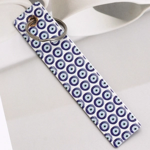 Faux leather evil eye charm keychain with blue ethnic patterns and silver metal ring
