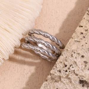 Macro shot of silver multi-layer woven texture ring on a natural seashell background