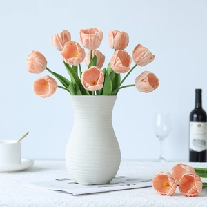 Elegant mini PU tulips in pink color placed in a white textured ceramic vase