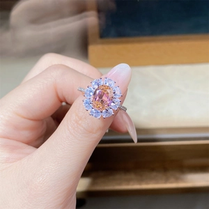 Close-up of elegant flower-shaped silver ring with champagne oval stone on a finger