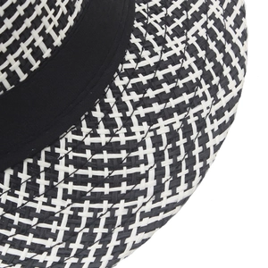 Detailed macro view of the fine black and white cross-weave texture on a straw jazz hat
