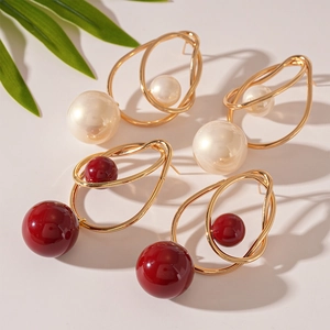 Modern double layer hollow gold earrings with white and red acrylic beads on pink background
