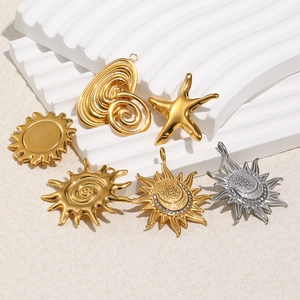 Assorted gold and silver 18K plated sun and moon pendants with rhinestones on white base