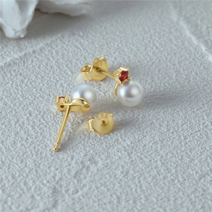 Macro view of S925 sterling silver earring with white pearl and red gemstone detail