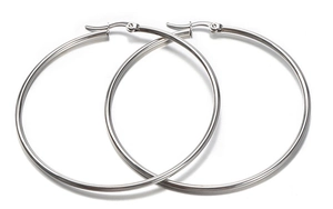 Detailed close-up of large polished silver hoop earrings with secure latch back closure