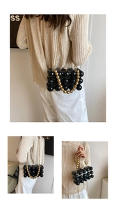 Detailed view of a black acrylic sphere beaded clutch with elegant gold chain strap
