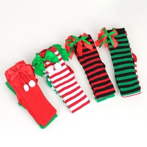 Detailed view of striped Christmas socks with festive bow knots and plush pom-poms