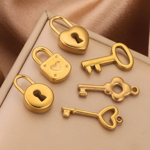Golden stainless steel heart lock and key charms on elegant fabric background