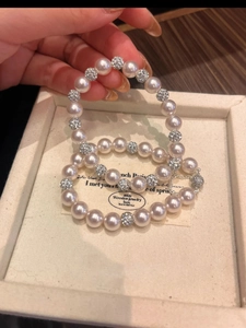 Detailed view of pearl bracelet with diamond-encrusted spacers on an elegant jewelry box
