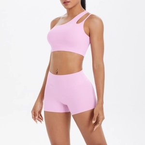 Detail of pink one-shoulder yoga sports bra and high-waisted shorts set in soft nylon