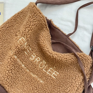 Détail du tissu pelucheux avec broderie Crème Brûlée sur un sac fourre-tout brun