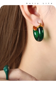 Detail of dark green resin C-shaped earrings and matching ring set for daily wear