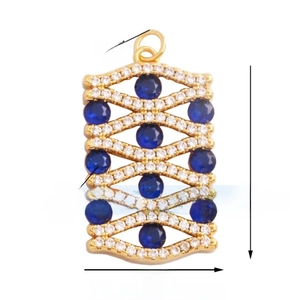 Detailed macro view of a rectangular gold pendant featuring blue stones and white zircon