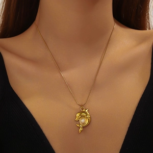 Gold-plated stainless steel dolphin pendant necklace with white gemstone on female model