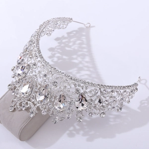 Macro shot of silver wedding crown featuring intricate vine patterns and sparkling rhinestones