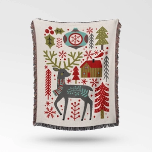 Close-up of woven Christmas throw blanket with reindeer, cabin, and colorful fringe edges
