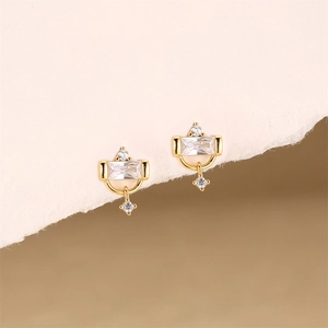 Detailed macro view of gold-plated earrings featuring emerald-cut clear cubic zirconia