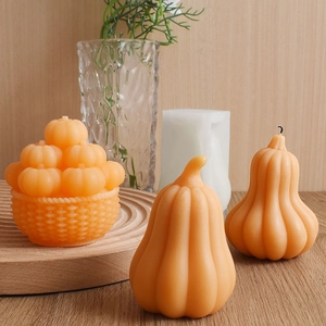 Three orange pumpkin scented candles arranged on a wooden tray with warm decor
