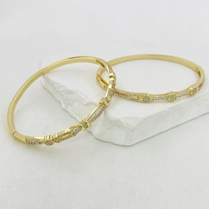 Lussuosi bracciali aperti placcati oro con zirconi lucenti su pietra decorativa