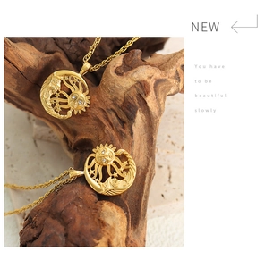 Detailed close-up of a gold sun and moon pendant with shimmering crystal accents